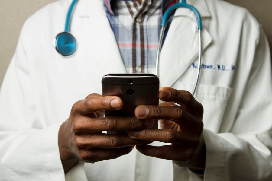 Arzt mit Stethoskop und Smartphone